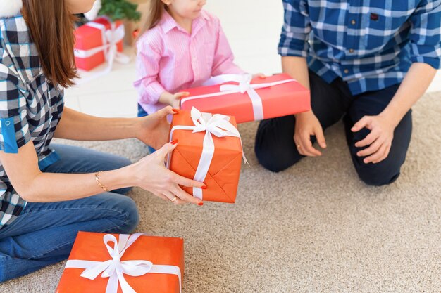 Holidays and presents concept - Portrait of a happy family opening gifts at Christmas time.