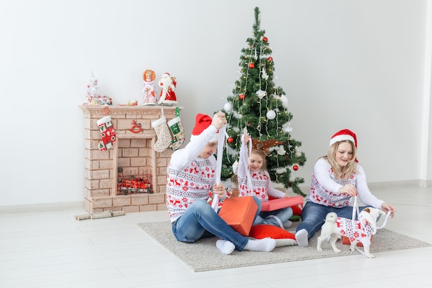 Holidays and presents concept - Portrait of a happy family opening gifts at Christmas time.