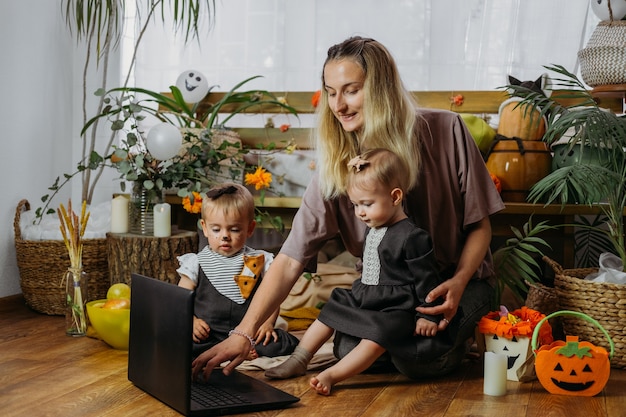 Holidays in the time of covid happy family mother and baby celebrating halloween via internet in new