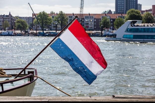 Foto bandiera dell'olanda che ondeggia su una barca a rotterdam