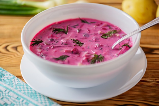 Holodnik of beets, egg and greens on a wooden table. Russian traditional kitchen.