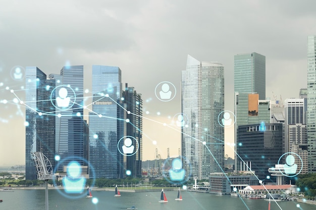 Hologram of social media icons over sunset panoramic cityscape of Singapore Southeast Asia The concept of people connections and career opportunities in international consulting Multi exposure