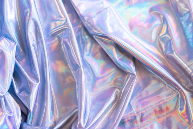 Holographic iridescent mermaid foil texture background. Futuristic neon trendy silver colors