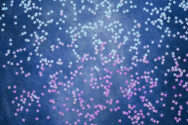 Holographic stars confetti on dark blue. Festive.