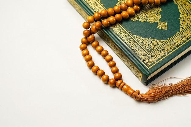 Holy Al Quran 아랍어 서예 및 묵주 구슬 또는 tasbih 녹색 검정색 배경 복사 공간