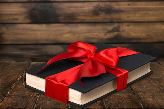 Photo holy bible book with red bow on wooden background