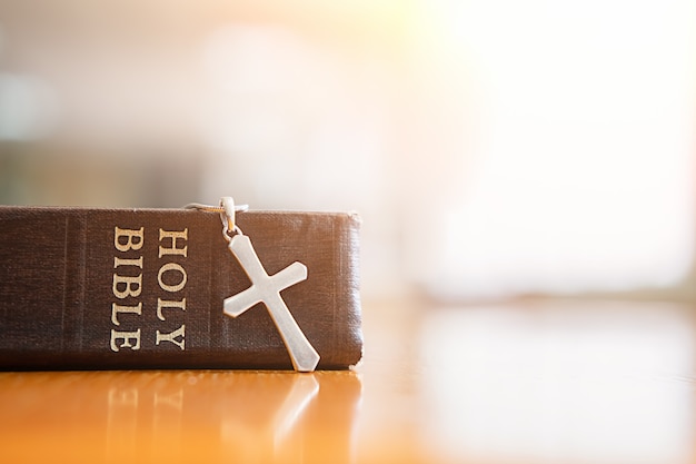 Holy bible and cross on table. 