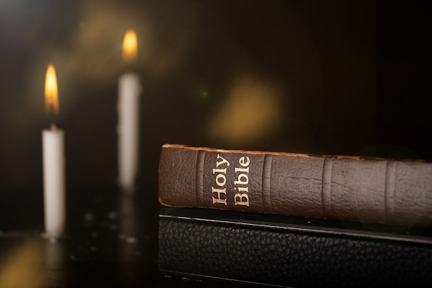 Holy bible on table with soft light from candle .Religion concept.