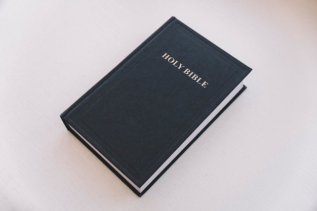 Библия на белом столе концепция веры и религии христианская вера