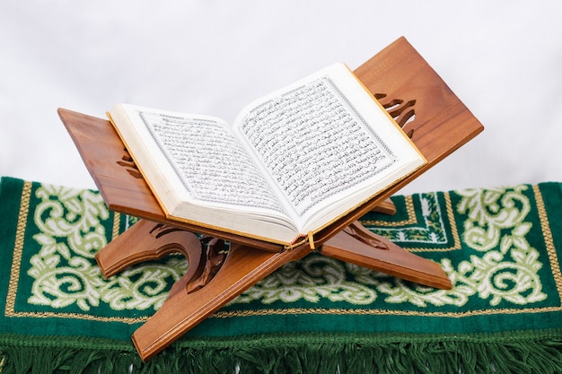 Photo the holy book al quran and prayer rug isolated on white background