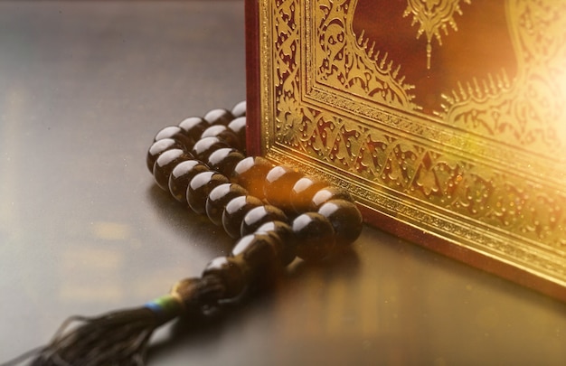 Photo holy book and beads on table, close up