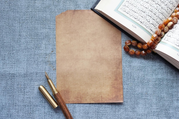 Holy book Quran and a empty paper on table