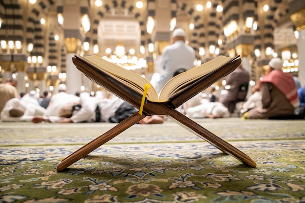 the holy book of the quran is opened on a green carpet at the prophet mosque masjid nabawi