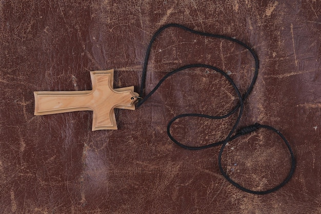 Holy Wooden Cross isolated on brown leather background