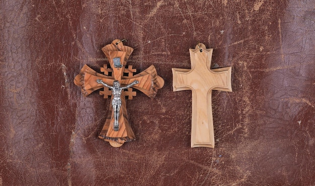 茶色の革の背景に分離された聖なる木製の十字架
