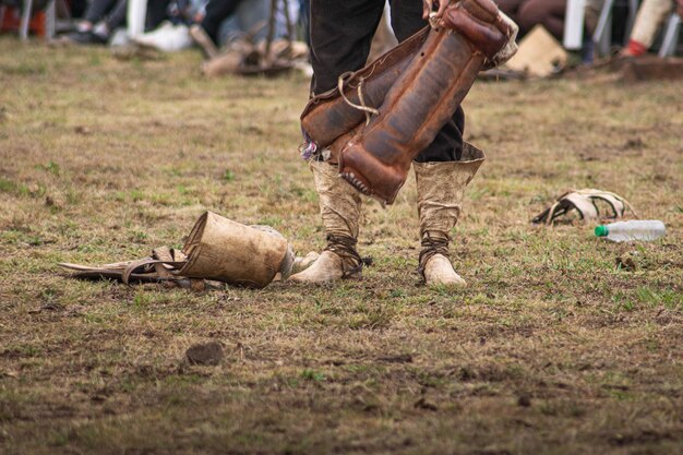 hombre con un apero en la mano y botas de cuero Tradicion argentina
