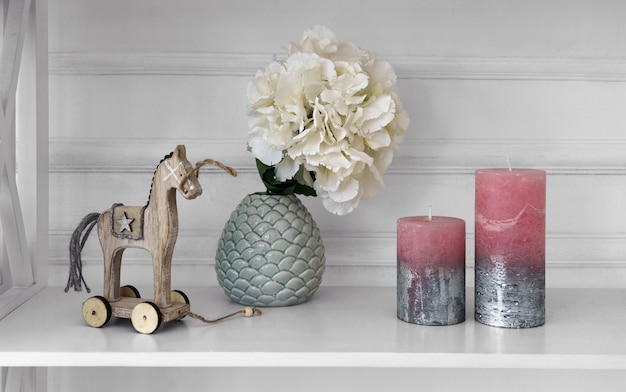 Photo home accessories vase and wooden horse beside candles