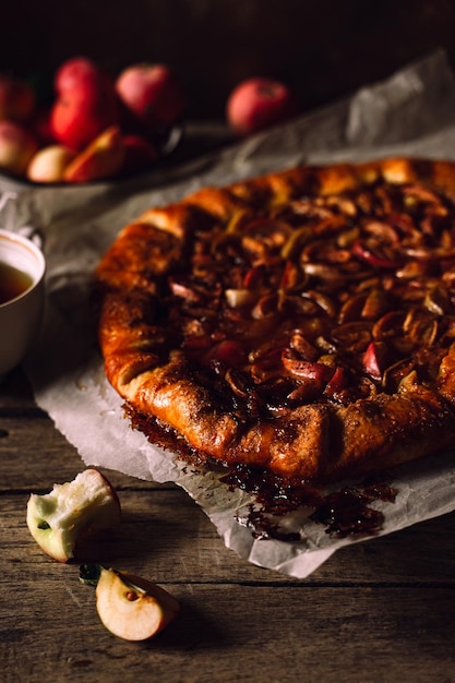 Home baked apple pie fresh apples on rustic wooden table closeup view