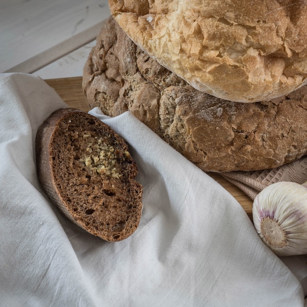 Home baked Fresh bread garlic  on a beige napkin and wooden table