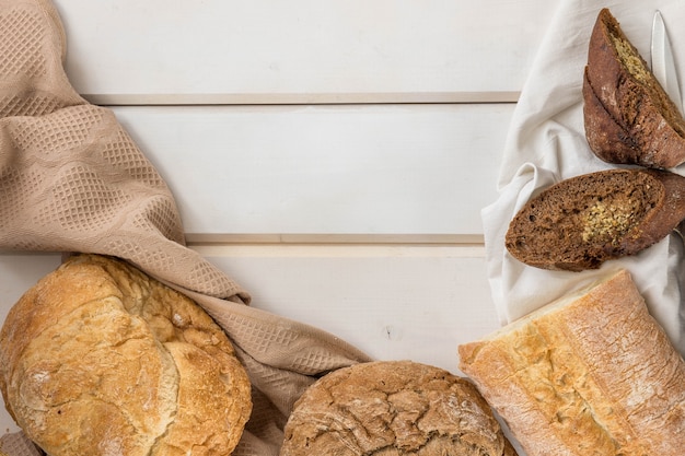 Pane fresco cotto in casa su un tovagliolo bianco e un tavolo di legno con uno spazio di copia