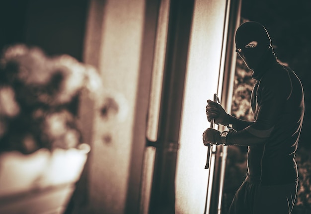 Foto un ladro di casa con una maschera che entra in casa un ladro di casa concept photo