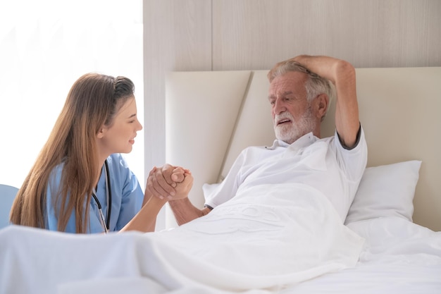 Home care and healthy insurance female doctor embracing\
encouraging happy senior male patient in hospital