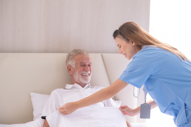 Home care and healthy insurance female doctor embracing encouraging happy senior male patient in hospital