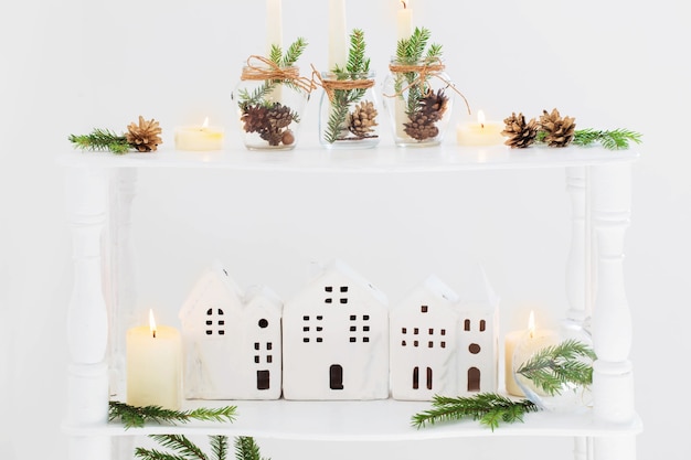 Home christmas decor with burning candles in whte interior