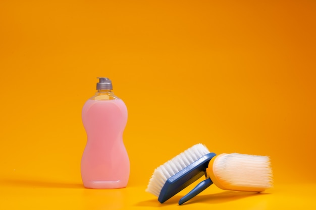 Home cleaning tools on yellow studio background