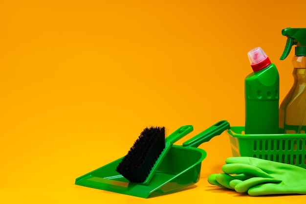 Home cleaning tools on yellow studio background