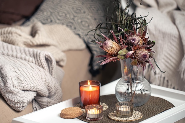 Photo home composition with a bouquet of protea flowers and candles