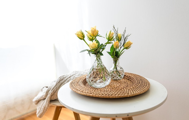 Home composition with flowers in a vase in the interior of a white room