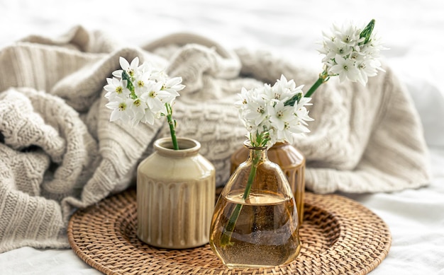 Home composition with flowers in vases and a knitted element