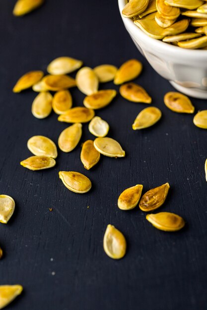 Home  cooked pumpkin seeds on black background.