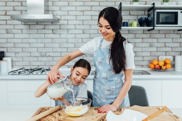 あなたの魂への家庭料理。小さな女の子と彼女の妹が家で料理を準備しました。おいしい家庭料理を調理する愛らしい料理人。ライフスタイル