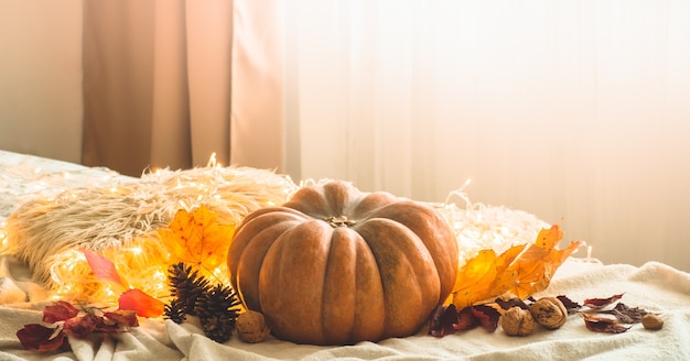 In casa decorata ghirlanda di zucca, coni, noci e foglie d'autunno. bella scena di concetto di festival di festa autunnale autunno, raccolto