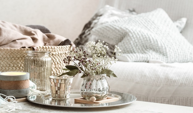 Home decoraties in het interieur. turquoise deken en rieten mand met een vaas met bloemen en kaarsen