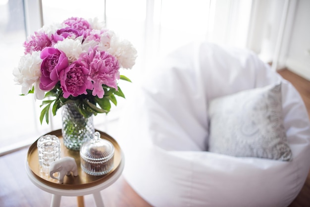 Home decoration fresh pink peonies on coffee table in white roo