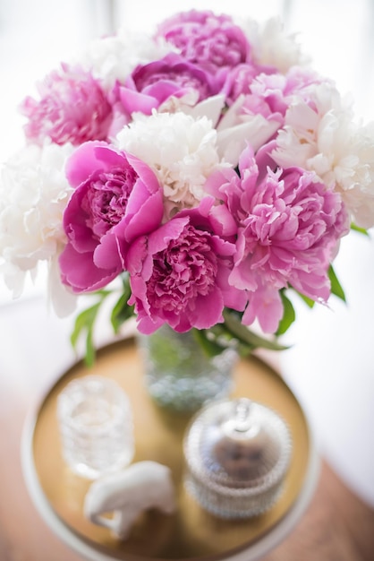 Foto peonie rosa fresche della decorazione domestica sul tavolino in roo bianco