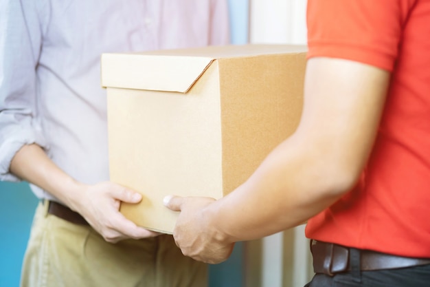 Home delivery, online order. A man in uniform, a medical mask and rubber gloves with a box