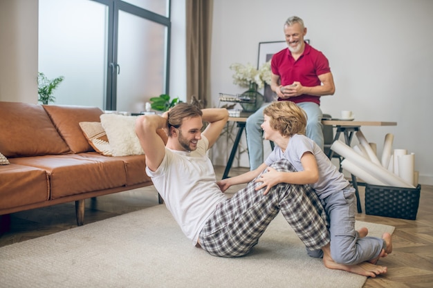 At home. Diverse family doing exercises at home and feeling good