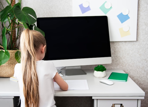 Home education. Girl working on desk at home