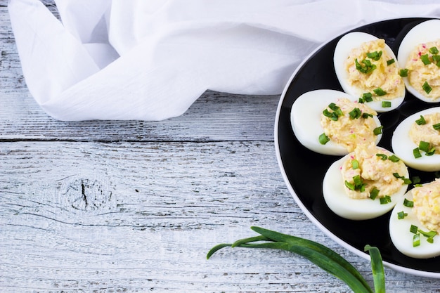 Home eggs stuffed with cheese and crab topped with green onions