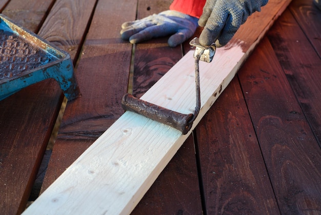 Home improvement handywoman painting wooden plank outdoors