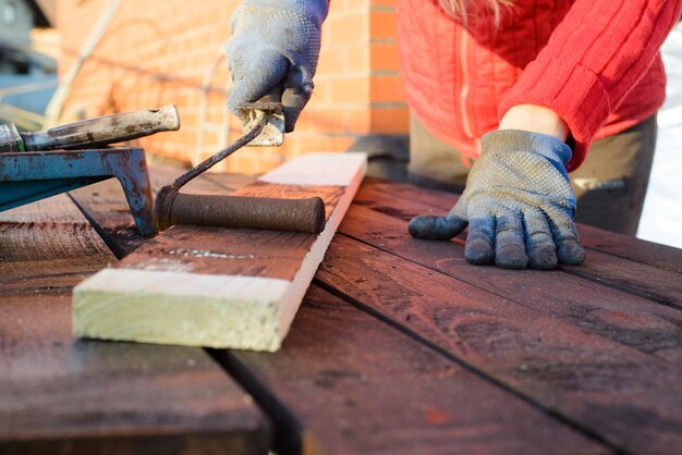 Home improvement handywoman painting wooden plank outdoors