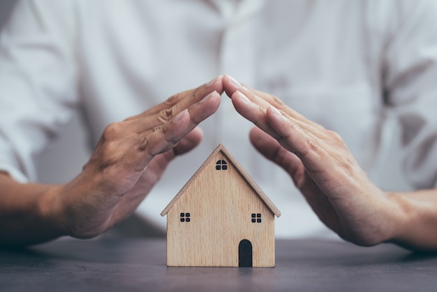 Страхование жилья для недвижимости и защитный жест человека и модели дома |  Премиум Фото