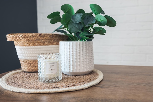 Home interior Still life with detailes Wicker basket with plants and candles on the kitchen table the concept of cosiness Close up