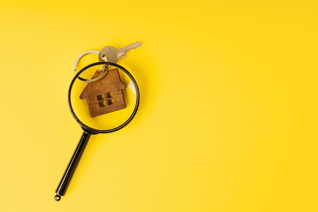 Photo home key with house through magnifying glass