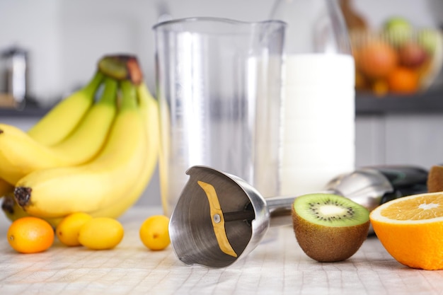home kitchen with ripe fruit table and hand blender. close-up.