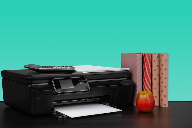 Home laser printer on desk against green background